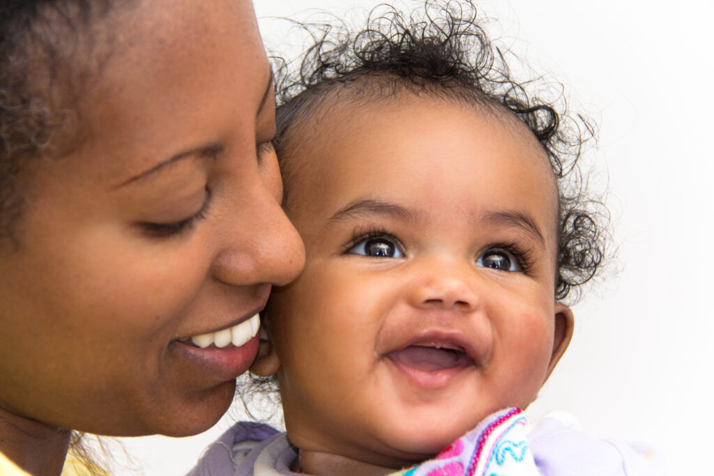 Mom kissing daughter